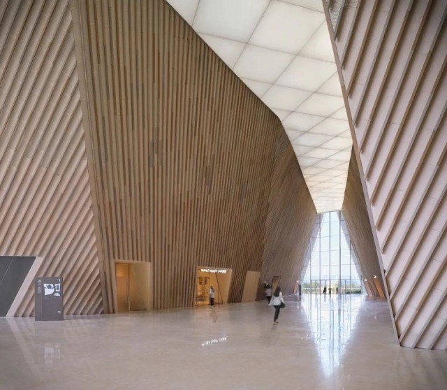 Sunlight filtering through the terracotta baguettes casts intricate patterns on the façade, creating a visually dynamic and ever-changing display of light and shadow.