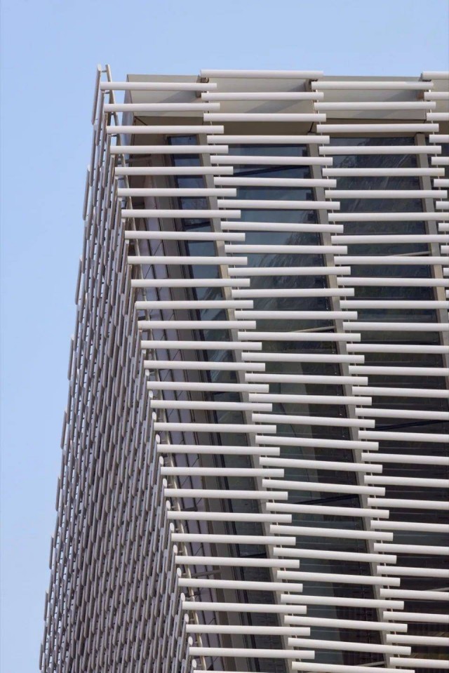 A detailed view of the terracotta baguettes, highlighting the intricate light and shadow effects created by their gradient design, contributing to the theatre’s unique aesthetic.